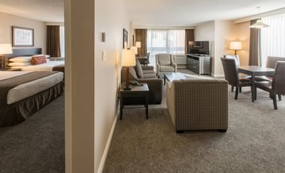 One-Bedroom Suite with two queen beds and a separate living area with a couch at Embassy Inn Victoria