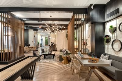 24-Hour Lounge with Games featuring a shuffleboard table, seating, and a lush wall decor at The Riverwalk Plaza Hotel