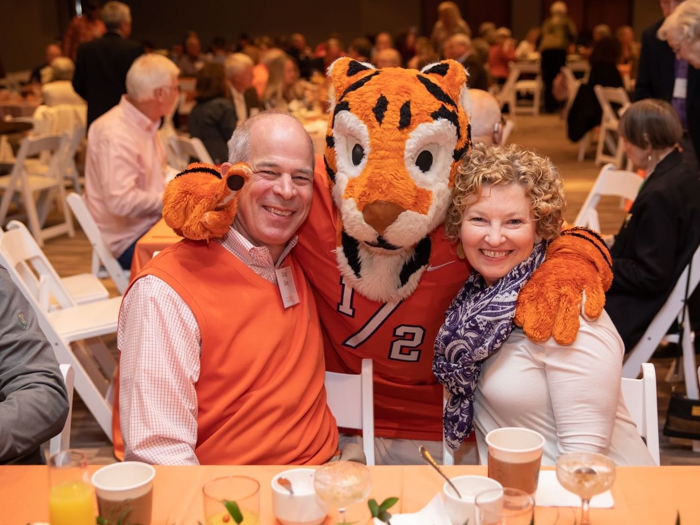 tiger mascot posing with couple