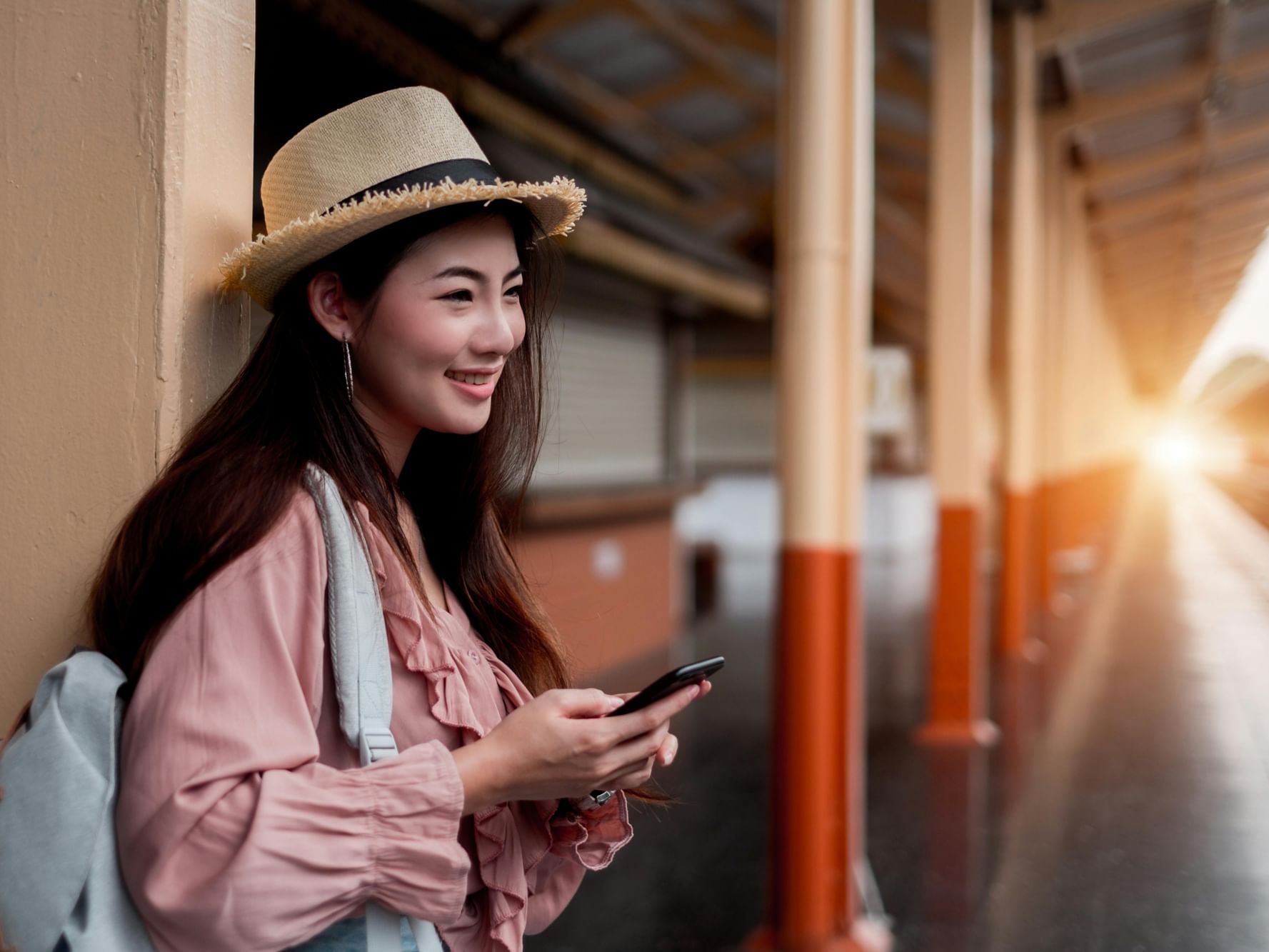 An Asian woman is focused on her mobile phone near Grand Park Otaru