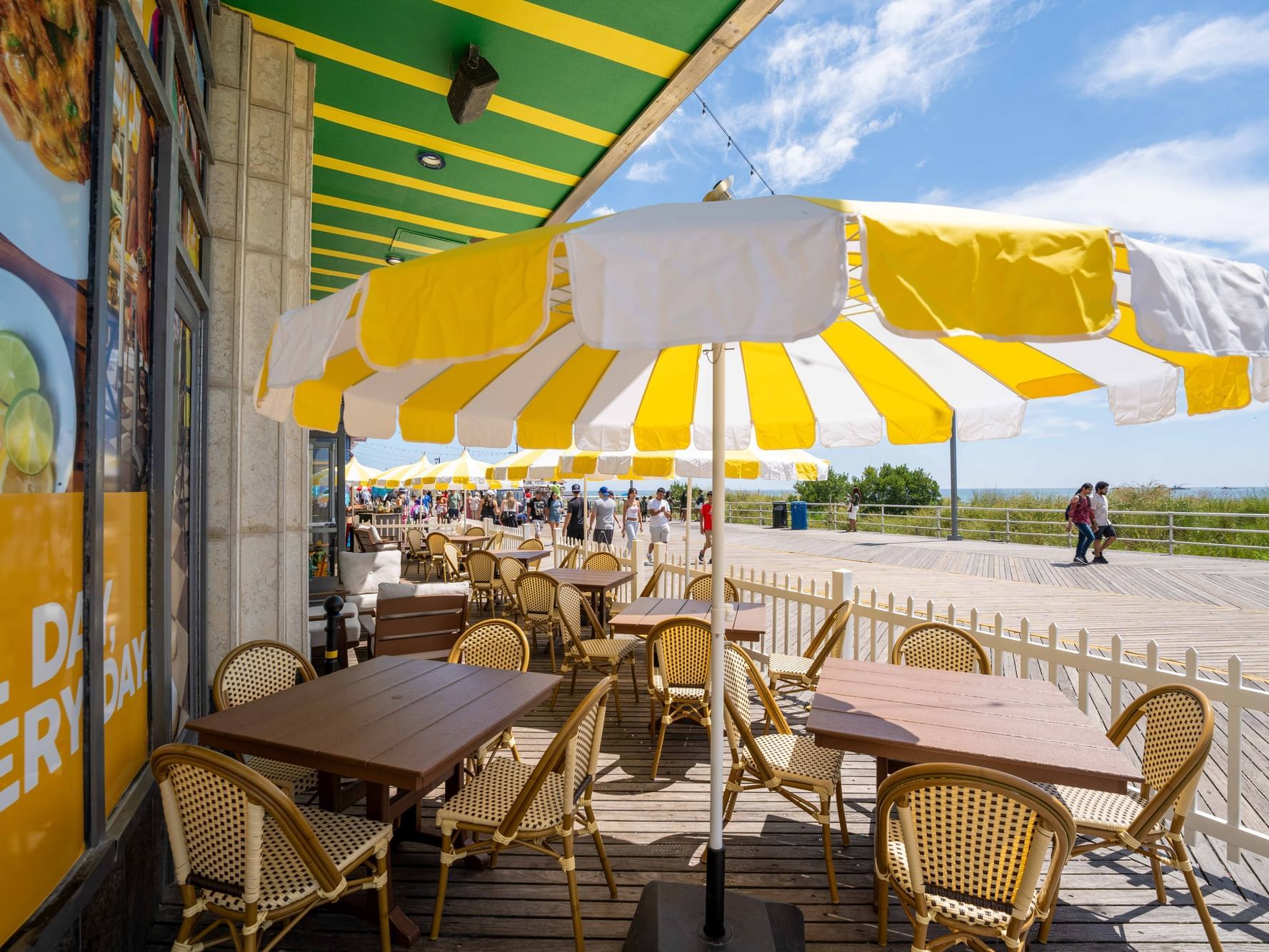 Limonada Bar with yellow-striped umbrellas and wicker chairs on a sunny boardwalk near Showboat Hotel & Resort
