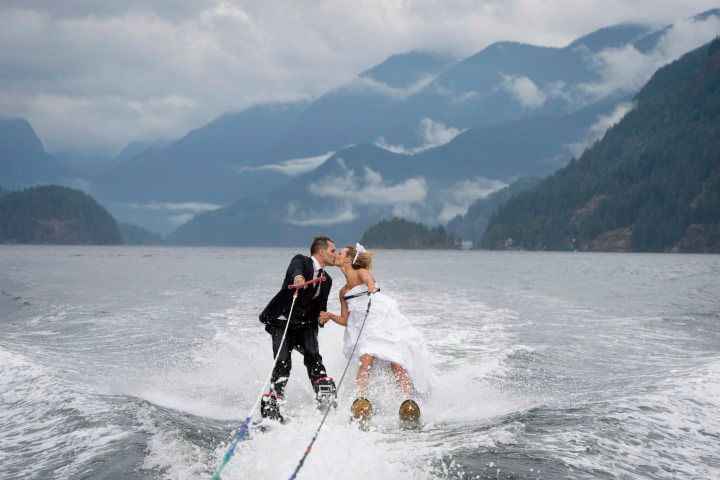 Happy couple kissing on waterskis.