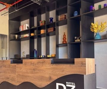 Reception counter with wooden panels & decorative items on black shelves at Unika Hotels, the best places to stay in Bogota