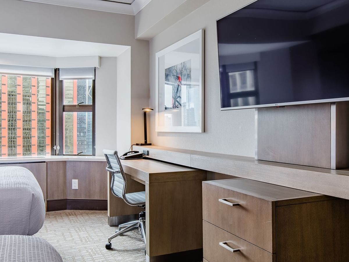 Hotel guestroom with two beds, TV, and desk