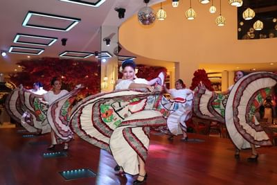 Dancers in traditional Mexican folkloric dresses performing with colorful swirling skirts at Playa Los Arcos Puerto Vallarta