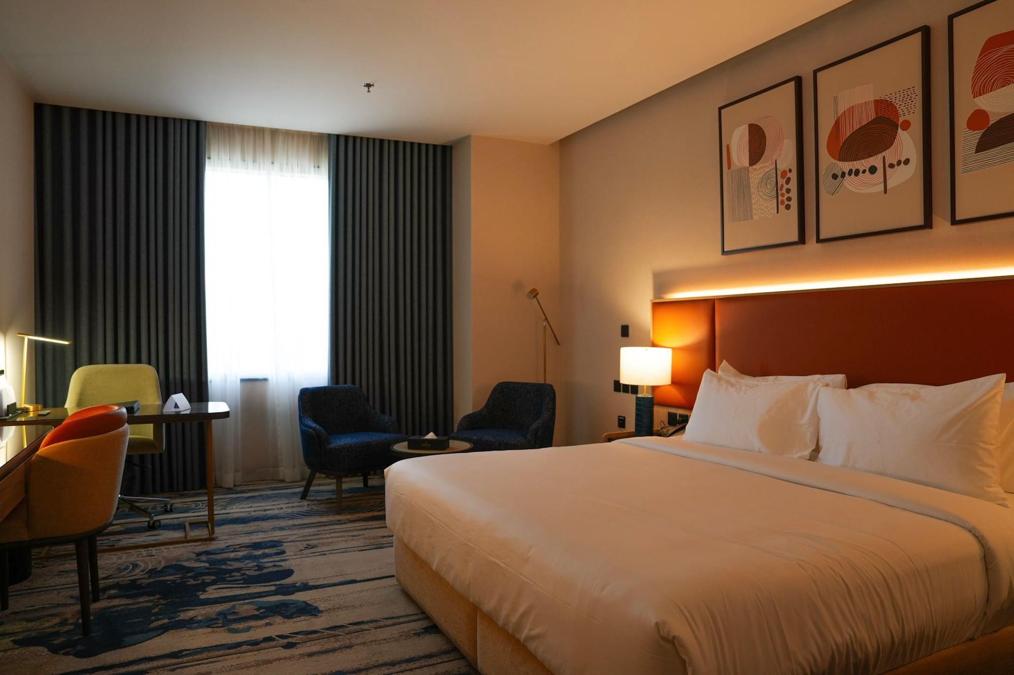 Comfortable hotel room with a bed, chairs, desk, and artwork at Warwick Hotel and Spa