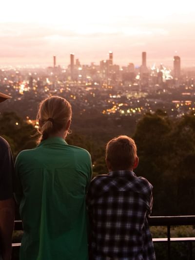 Family overlooking a cityscape at Mount Coot-tha near Sofitel Brisbane Central