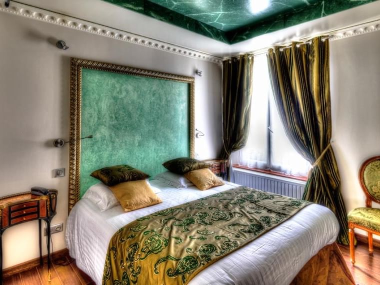 Chambre luxueuse avec lit, fauteuil et fenêtre à l'Hôtel Villa Aultia à Ault.