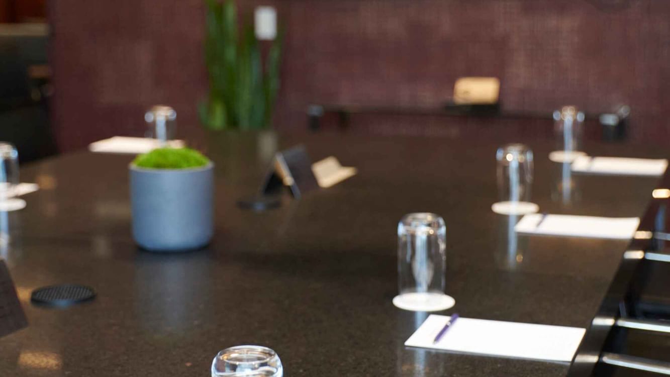 Professional boardroom table with glasses and notepads in Salon Du Président at Warwick Hotels and Resorts