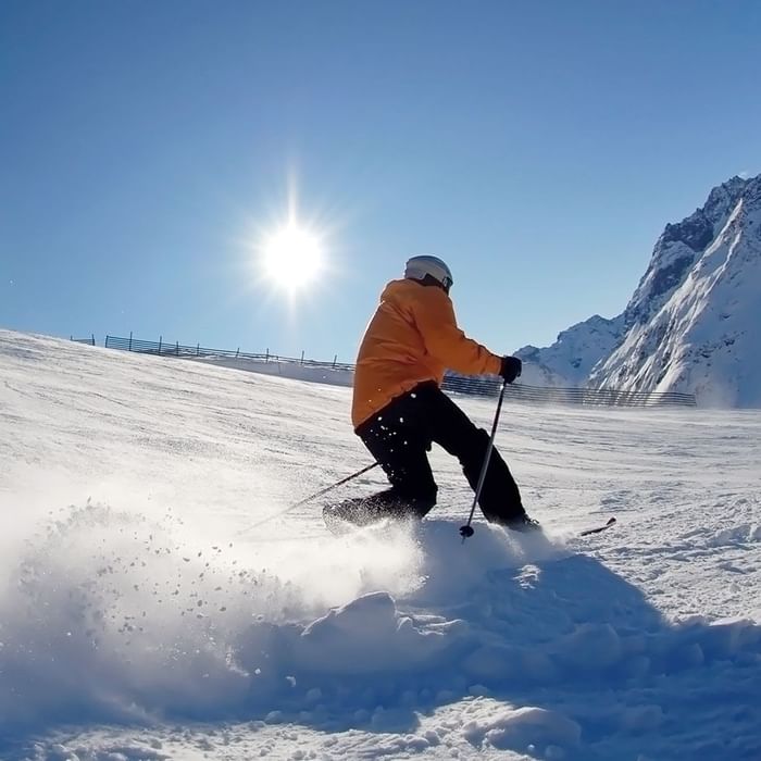 A man skiing on snow near Falkensteiner Hotels