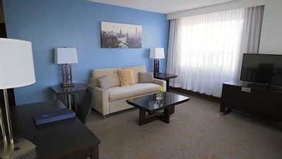 Living room with sofa & TV at Embassy Hotel & Suites Ottawa