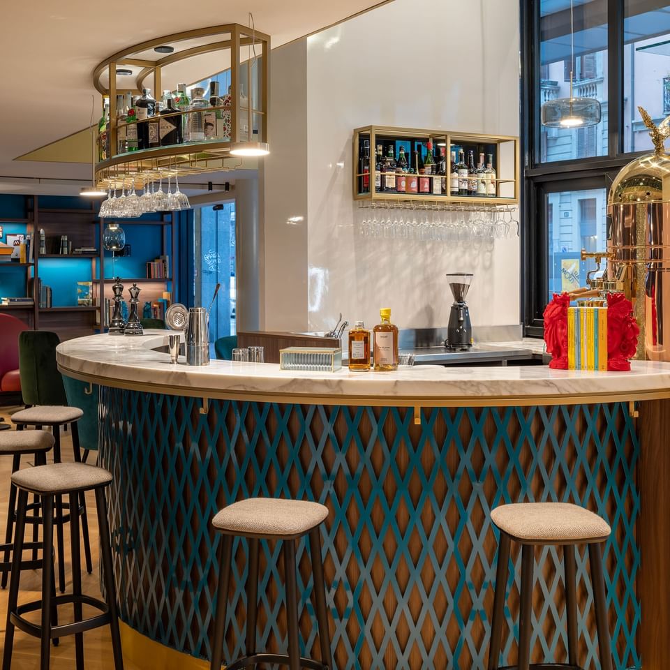 Bar counter with alcohol shelves & high chairs at Portico84