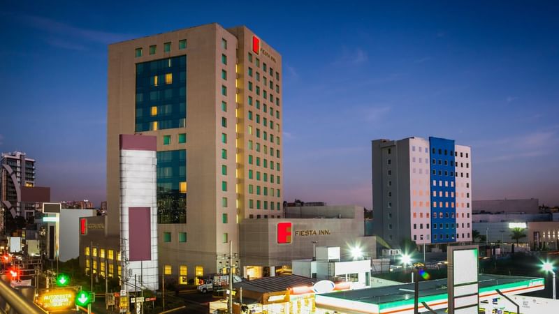 A distant view of FI Periférico Sur facade at night time