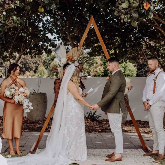 Romantic wedding ceremony with a flower-adorned arch at Pullman Magenta Shores