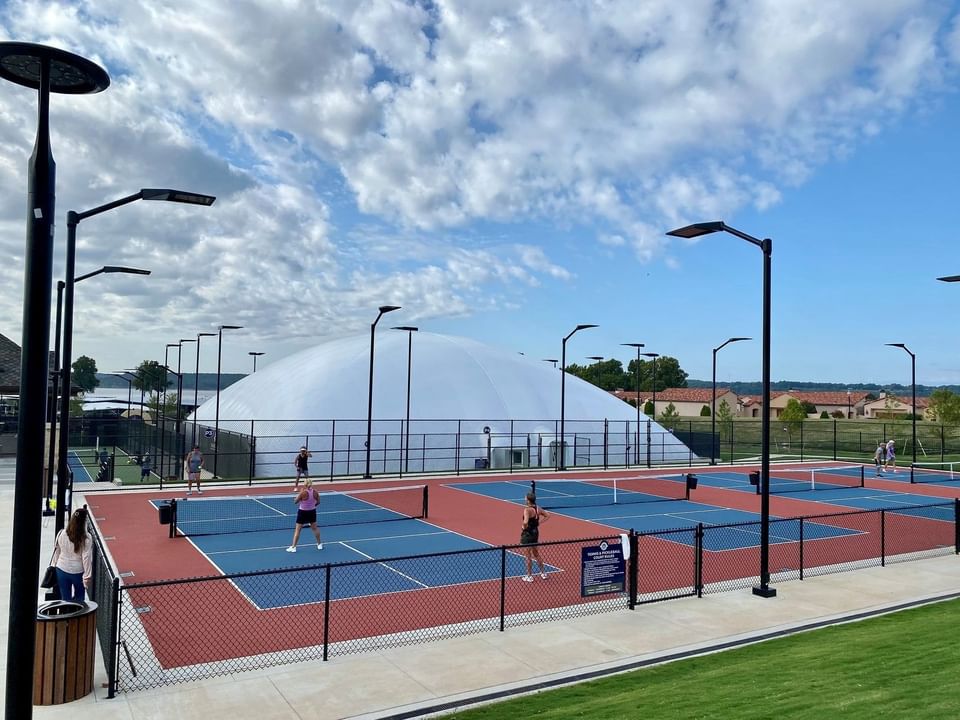 People playing in the outdoor tennis court at Shangri-La Monkey Island