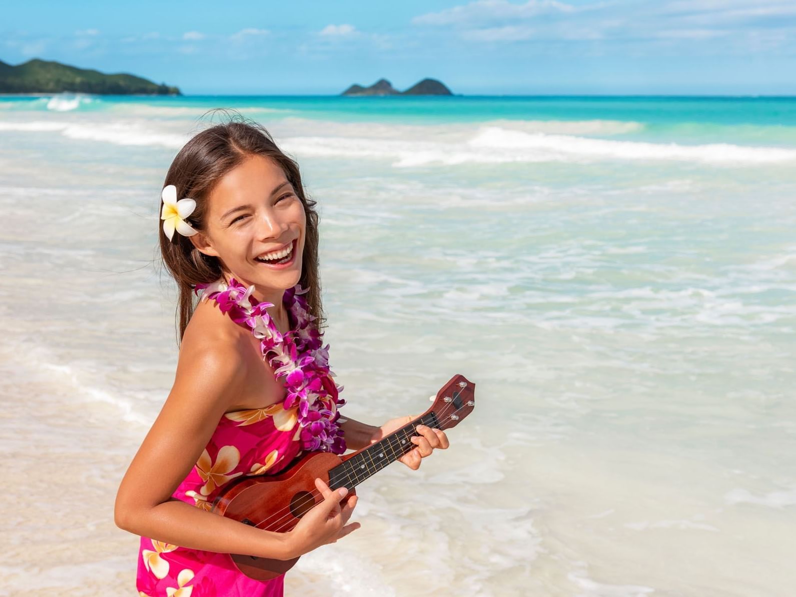 Hawaiian lady playing an ukulele on a beach at Maui Coast Hotel