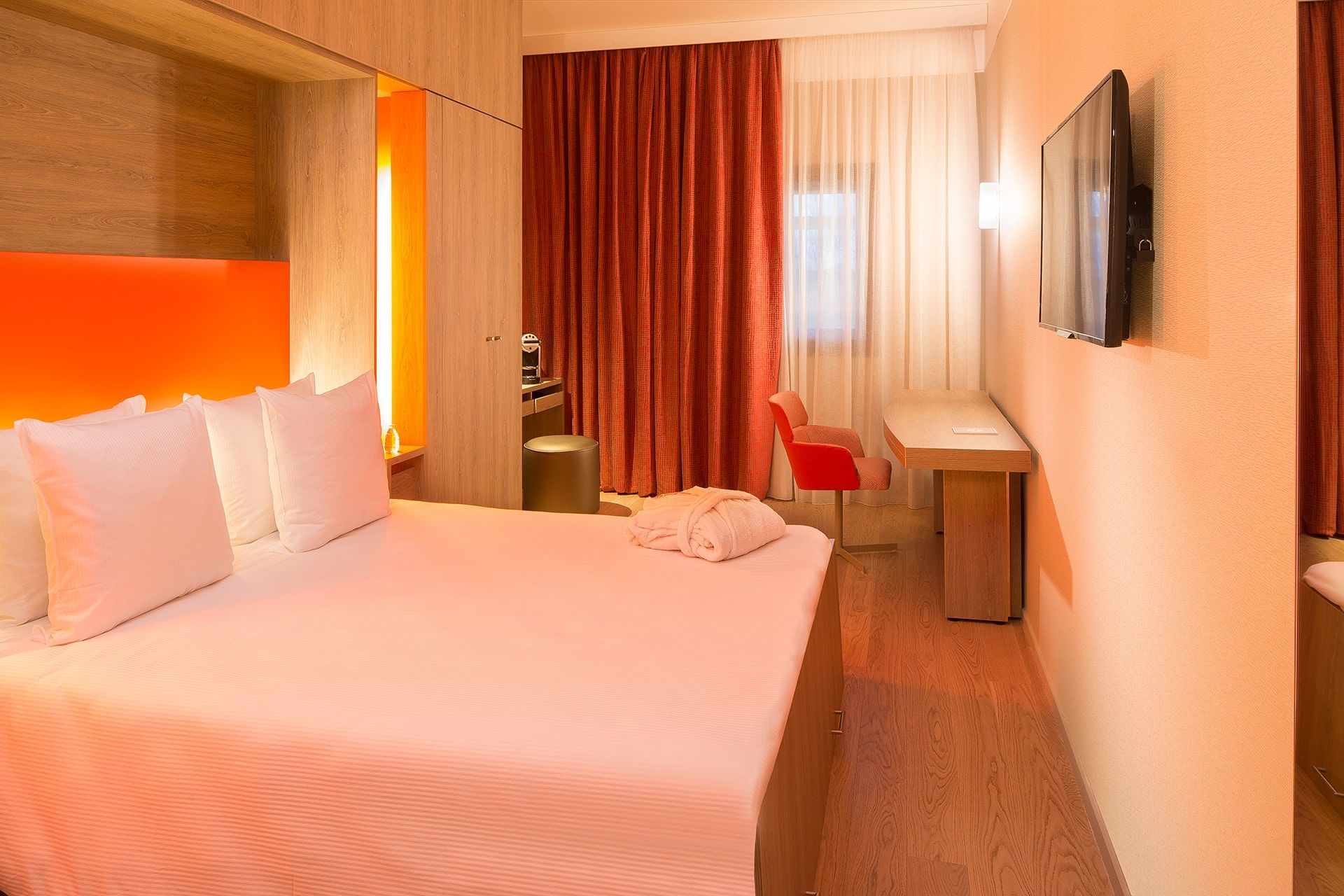 Lit king-size, TV et bureau dans une chambre à l'Oceania Paris Roissy CDG