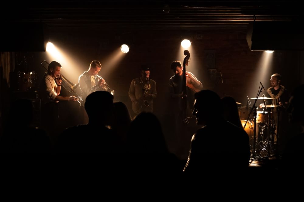 Jazz band performing under spotlights near a crowd in a dark lounge bar at Warwick San Francisco