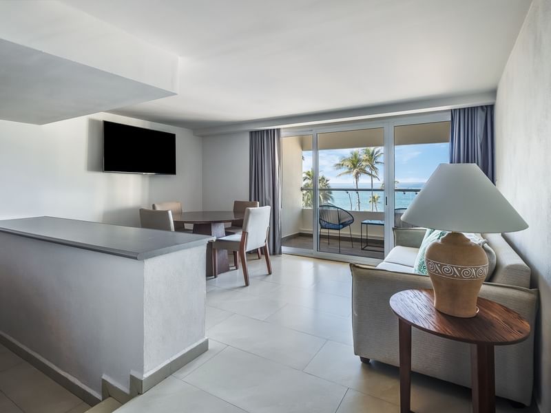 Junior Suite Vista Parcial Al Mar with a dining table, sofa, and balcony overlooking the ocean at Sunvivia Mazatlán