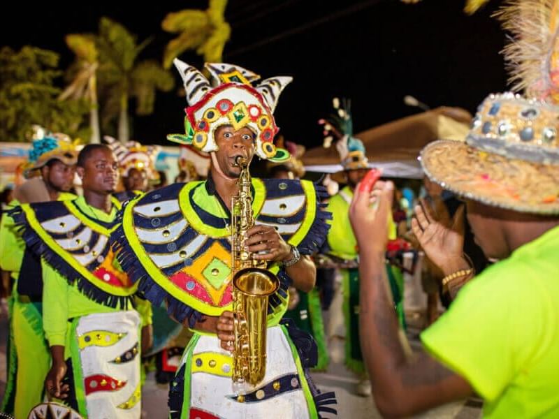 Vibrant parade scene featuring musicians in colorful costumes playing instruments near Windsong Resort On The Reef