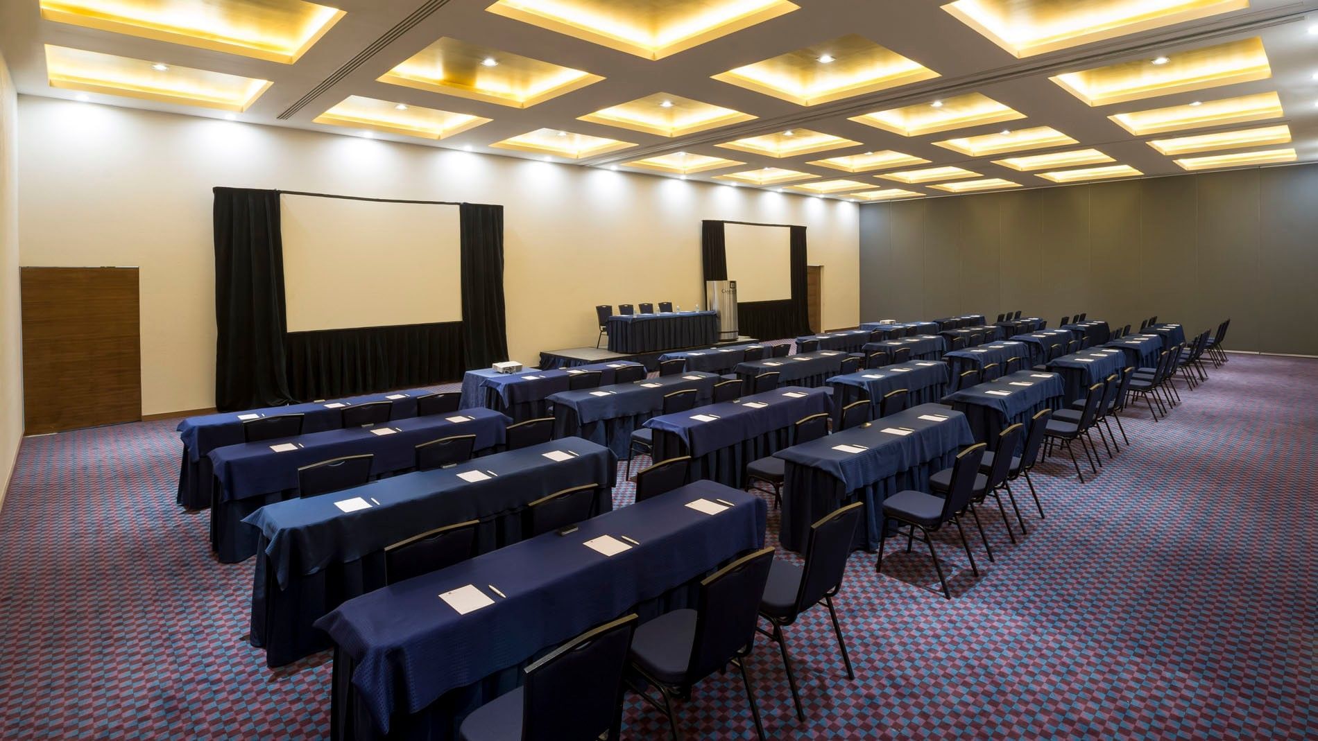 Gdl-Hmo classroom setup with blue tablecloths, white paper, and dual screens at Camino Real Pedregal Mexico