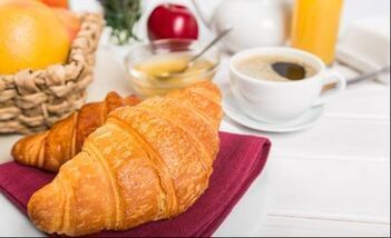 Delicious breakfast spread at Moab Valley Inn with croissants, fresh fruit, honey, coffee, and orange juice.