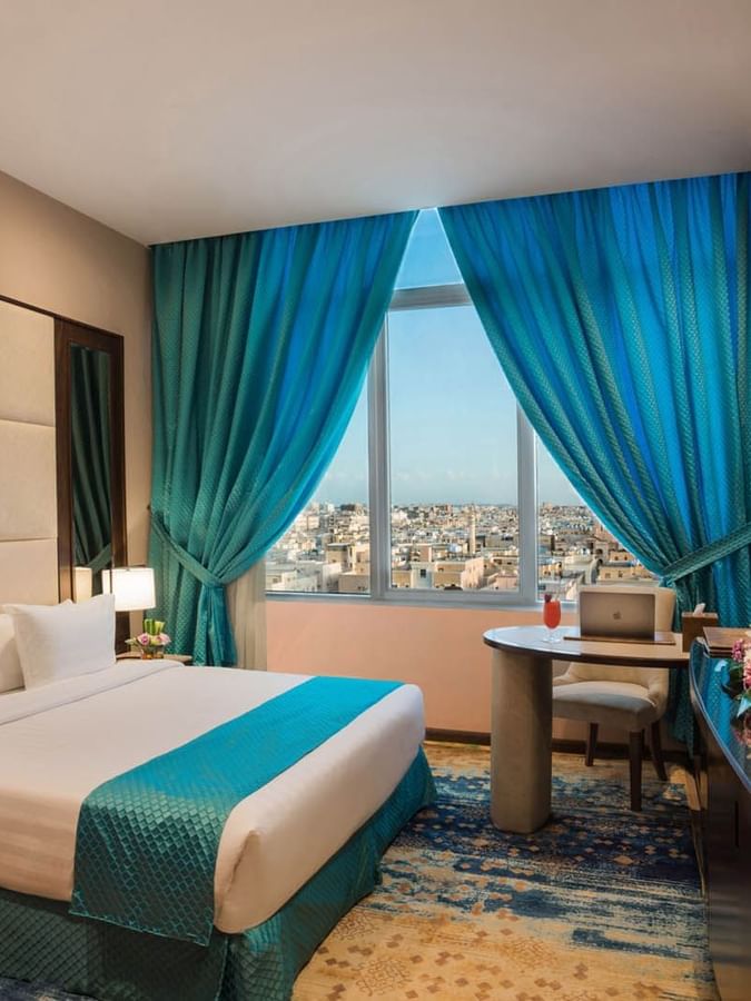 TV facing bed with a work desk  near the window in Junior Suite at Naviti By Warwick Dammam