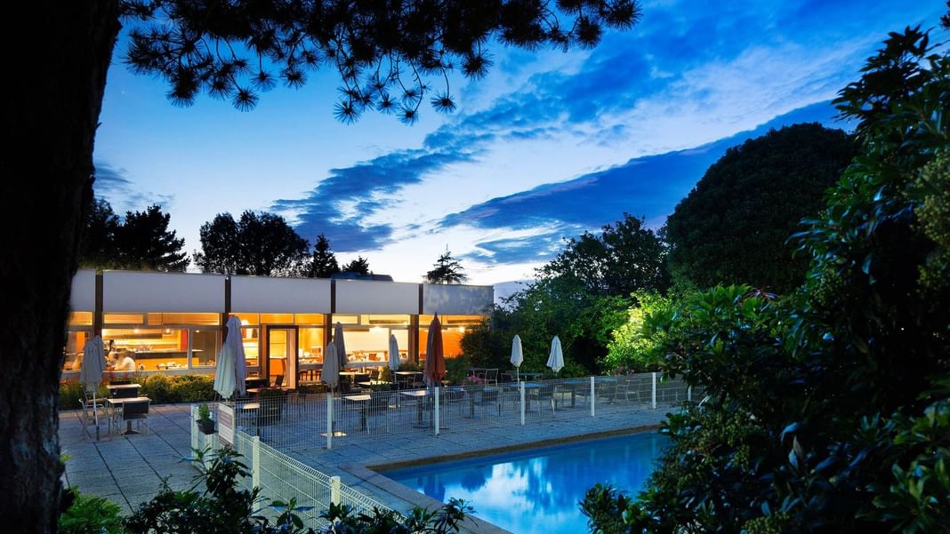 Outdoor dining area by the pool at Escale Oceania Brest Aeropot