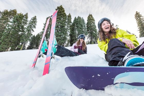 Two ladies skiing and snowboarding at Granlibakken Tahoe's ski and snowboard hill