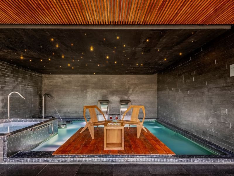 Piscina privada con sillas y mesa en suite de lujo en hotel.