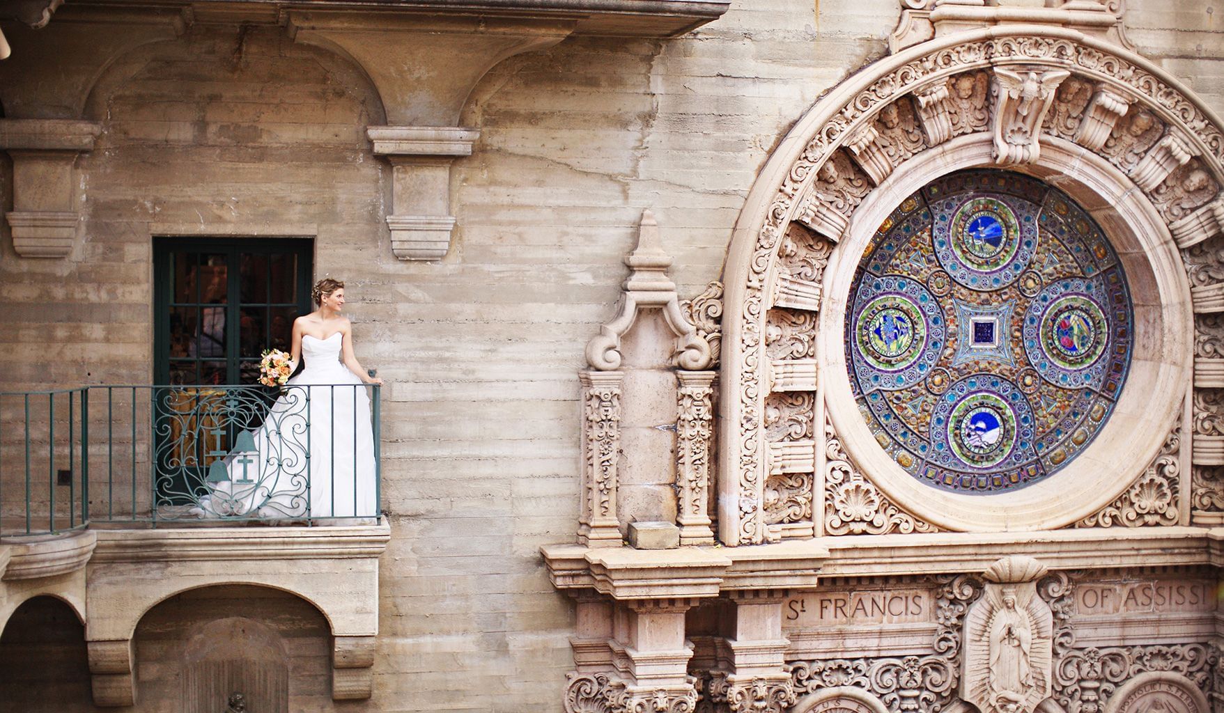 Bride on a balcony with flower bouquet at Mission Inn Riverside