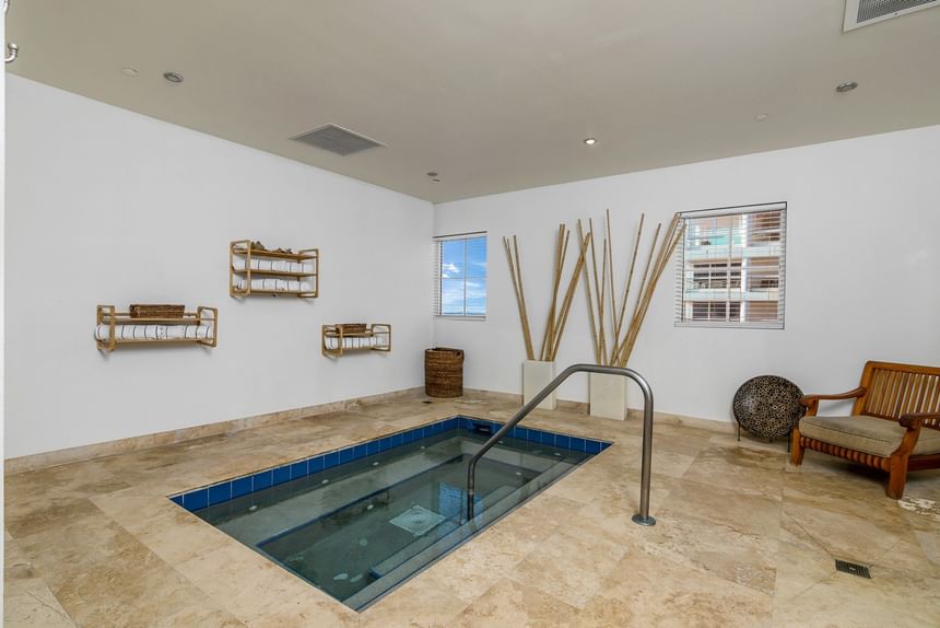 Indoor plunge pool with metal railing and bamboo decor in spa room at The Atlantic Hotel & Spa