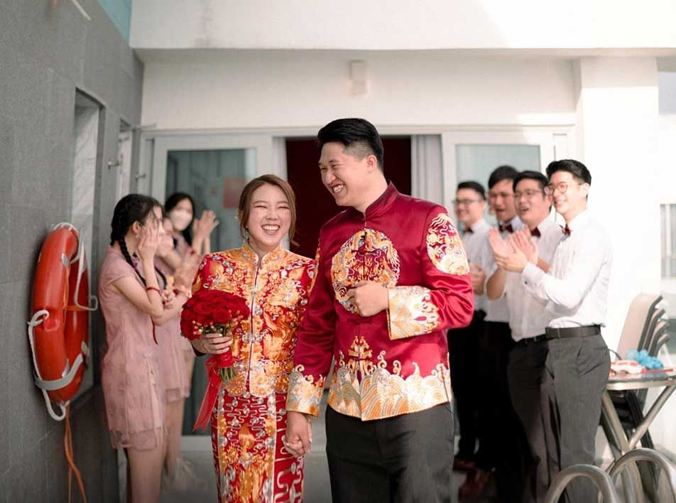 bride and groom holding hands and laughing with groomsmen and bridesmaids - Lexis MY