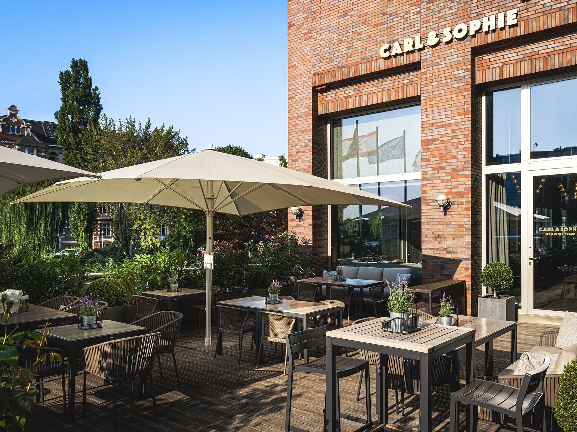 Outdoor dining area with tables, chairs, and umbrellas at Carl & Sophie.