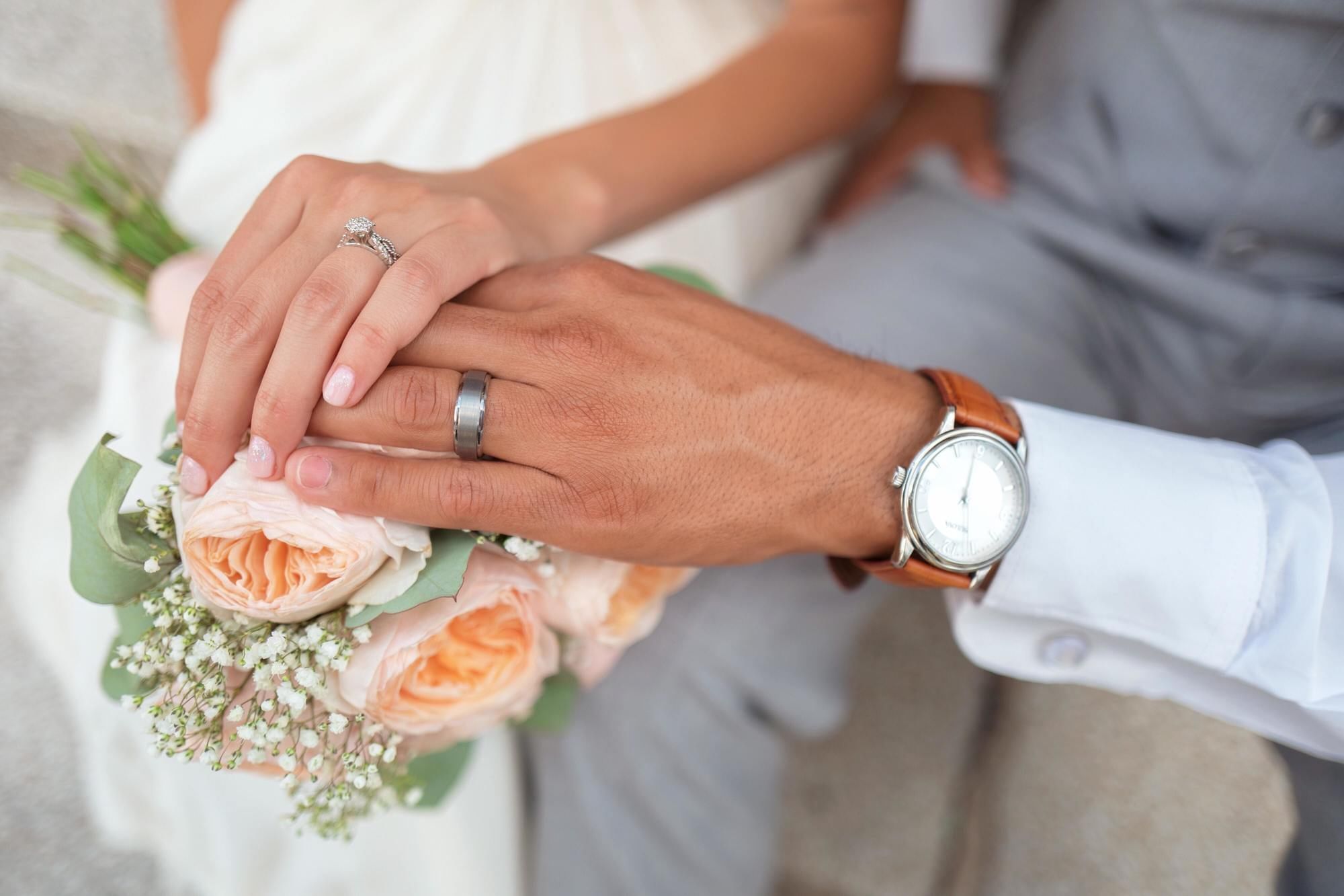 close up photo of wedding couple holding hands