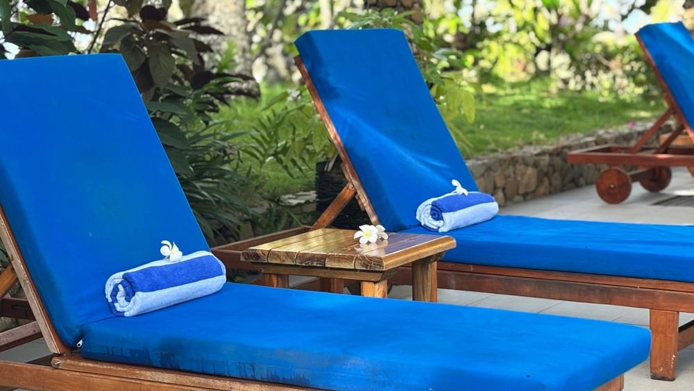 Blue cushioned loungers with a side table at Warwick Fiji Resort and Spa, Korolevu.