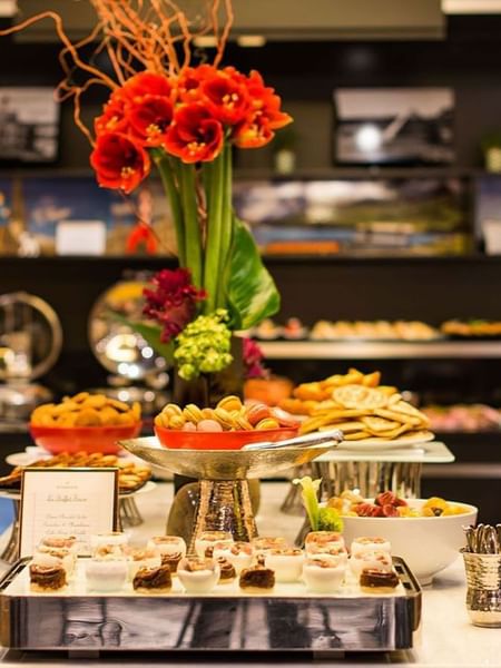 Floral centerpiece by tiered trays of pastries in Breakfast & 24-Hour Room Service at Warwick Paris Champs Elysées