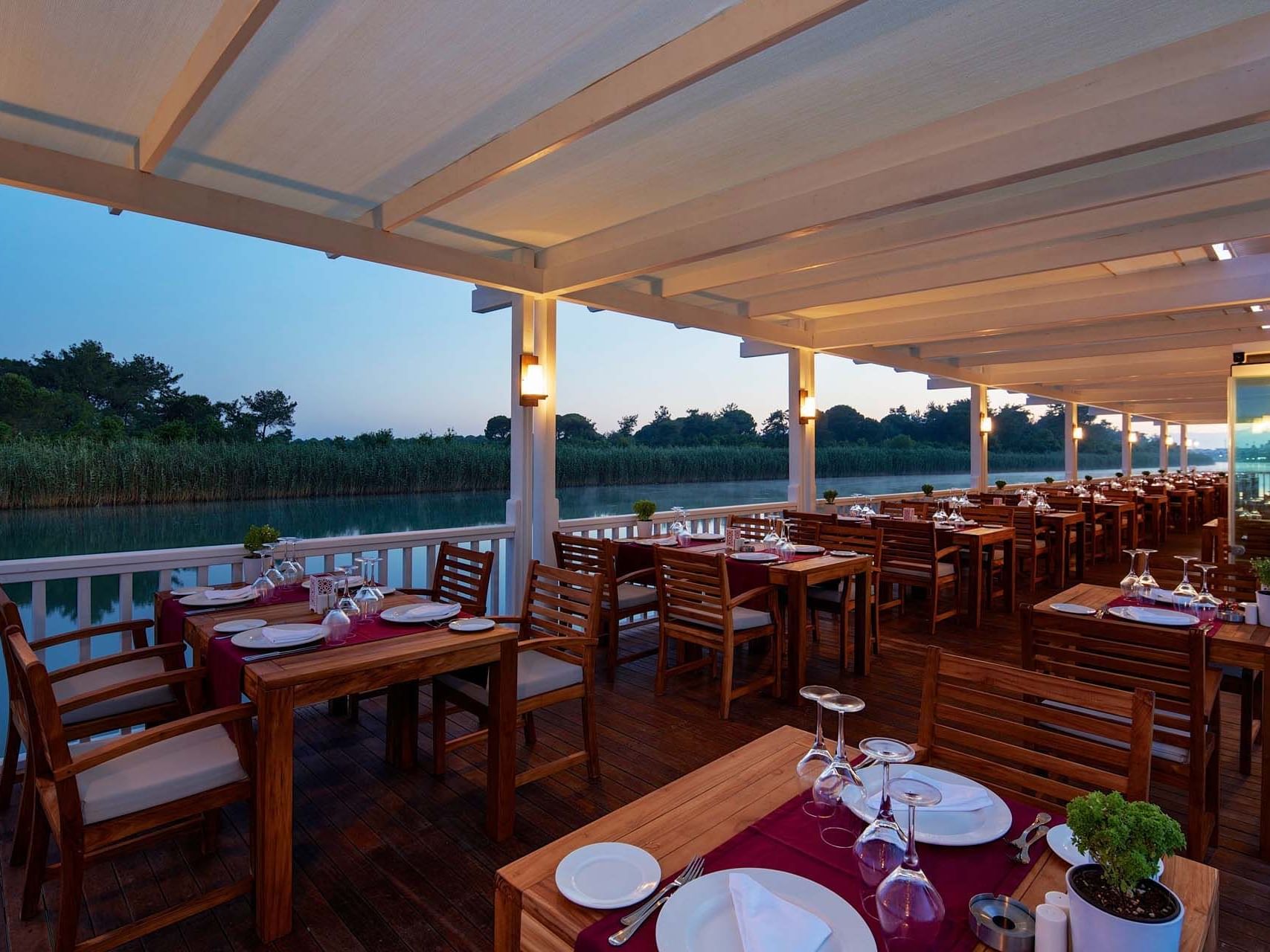 Dining setup on wooden deck in Hasır Turkish Restaurant at Titanic Deluxe Golf Belek