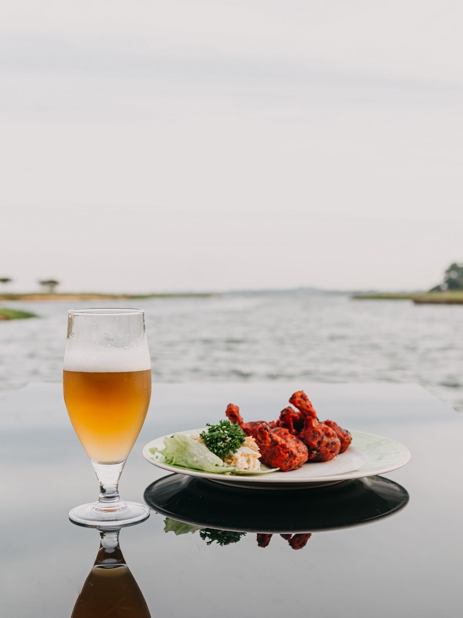 Marina Restaurant view with beer and chicken at Lake Victoria Serena Golf Resort & Spa, Kampala.