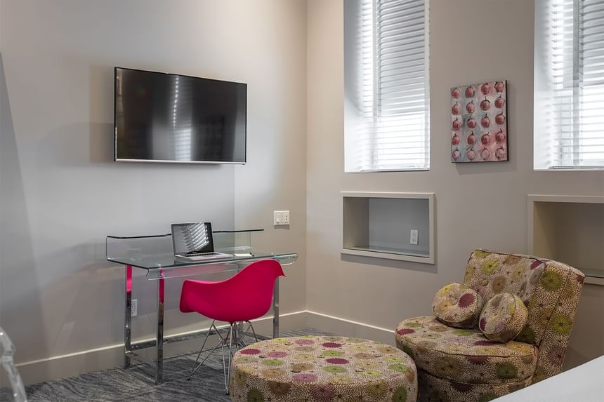 pink chair working at a glass desk with a computer 