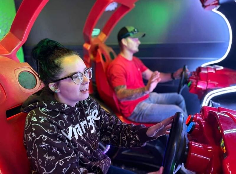 People enjoying a racing arcade game at the entertainment center near Shangri-La Monkey Island