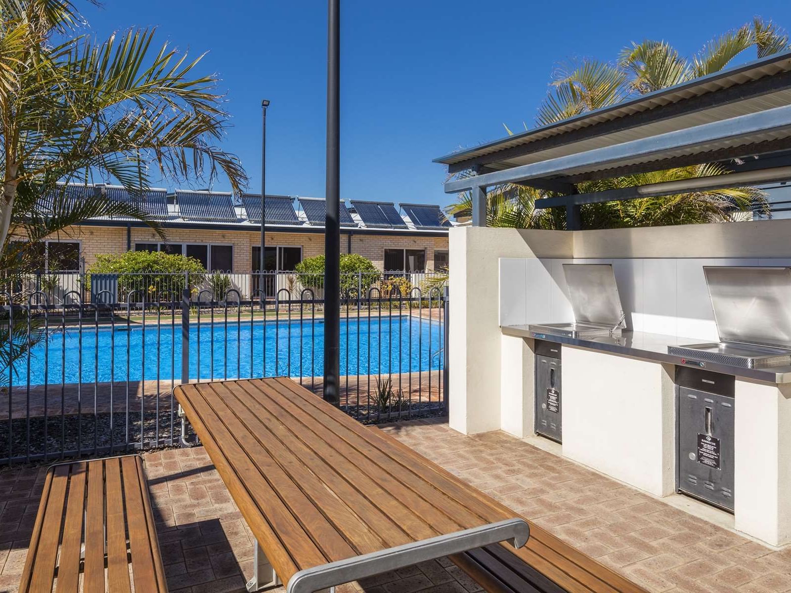 Sunbeds & grills by the outdoor swimming pool at Nesuto Hotels