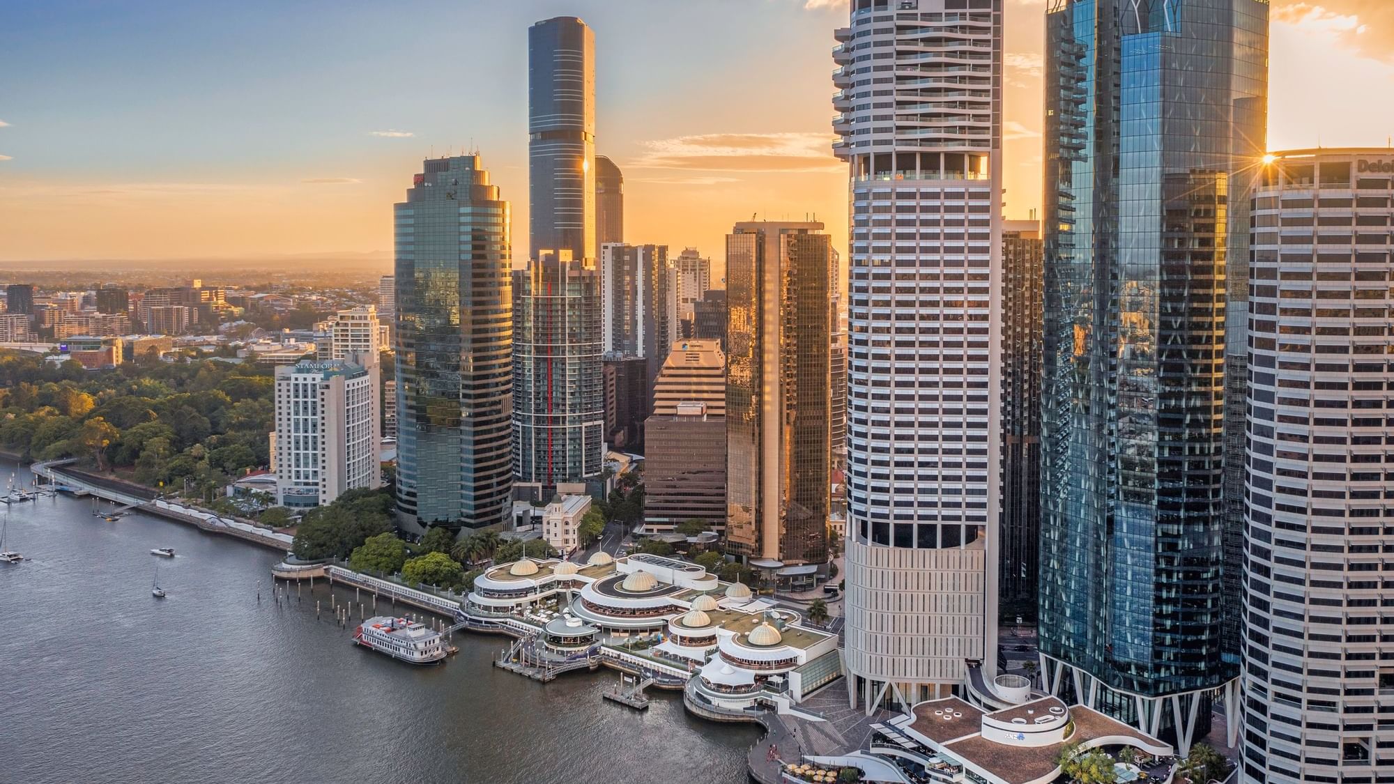 Aerial view of Eagle Street Pier with city skyline at sunset near Sofitel Brisbane Central