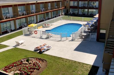 people tanning next to outdoor pool at hotel