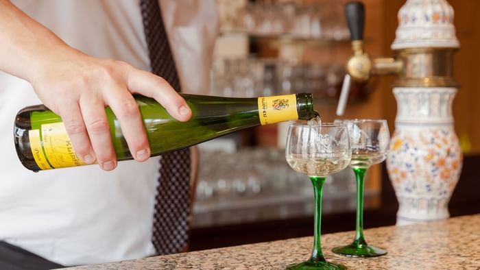 Bartender pouring whiskey into a glass at Hotel le forum 