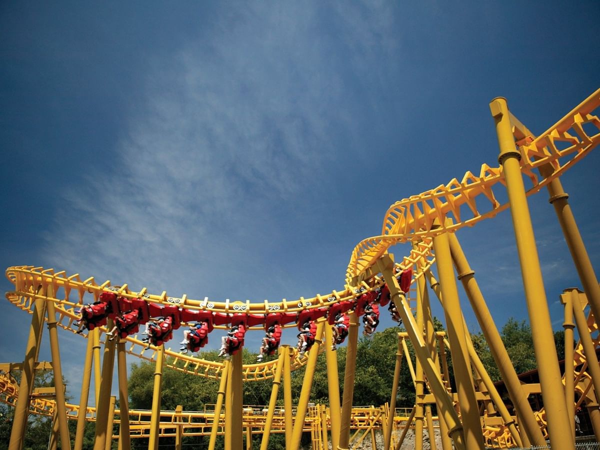 Roller coaster track with red cars under a blue sky in Magic Springs Theme and Water Park near Arlington Resort Hotel & Spa