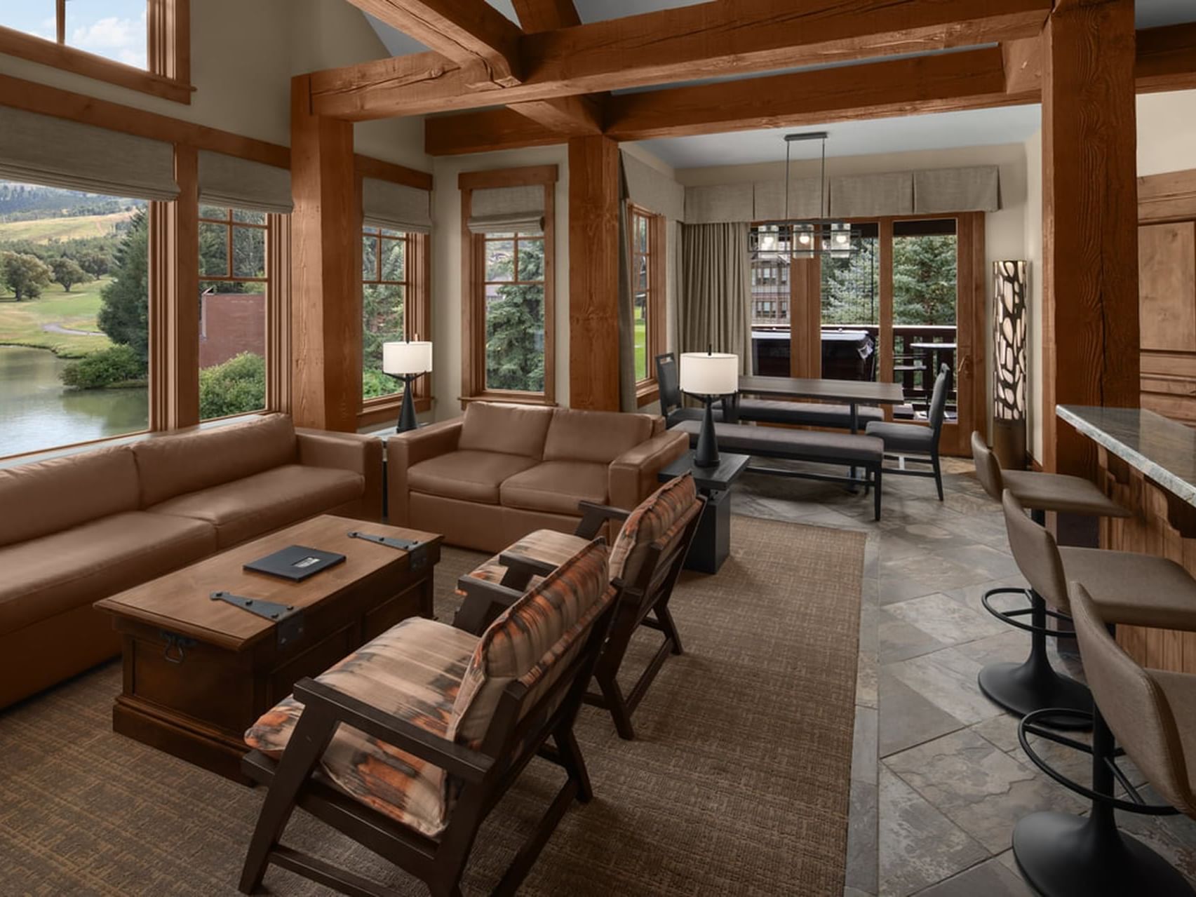 Living area with sofas, tables & green views in Cottage Luxury Suites at Hotel Park City Autograph Collection