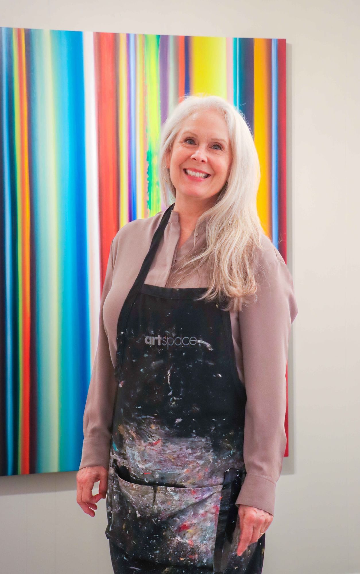 Woman in an apron posing for a photo in a vibrant background at Umstead Hotel and Spa