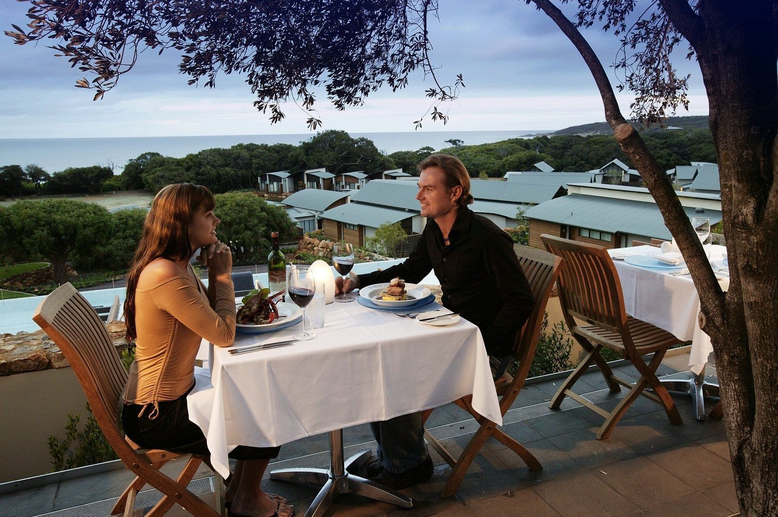 Couple having open air dinner at Pullman Bunker Bay Resort