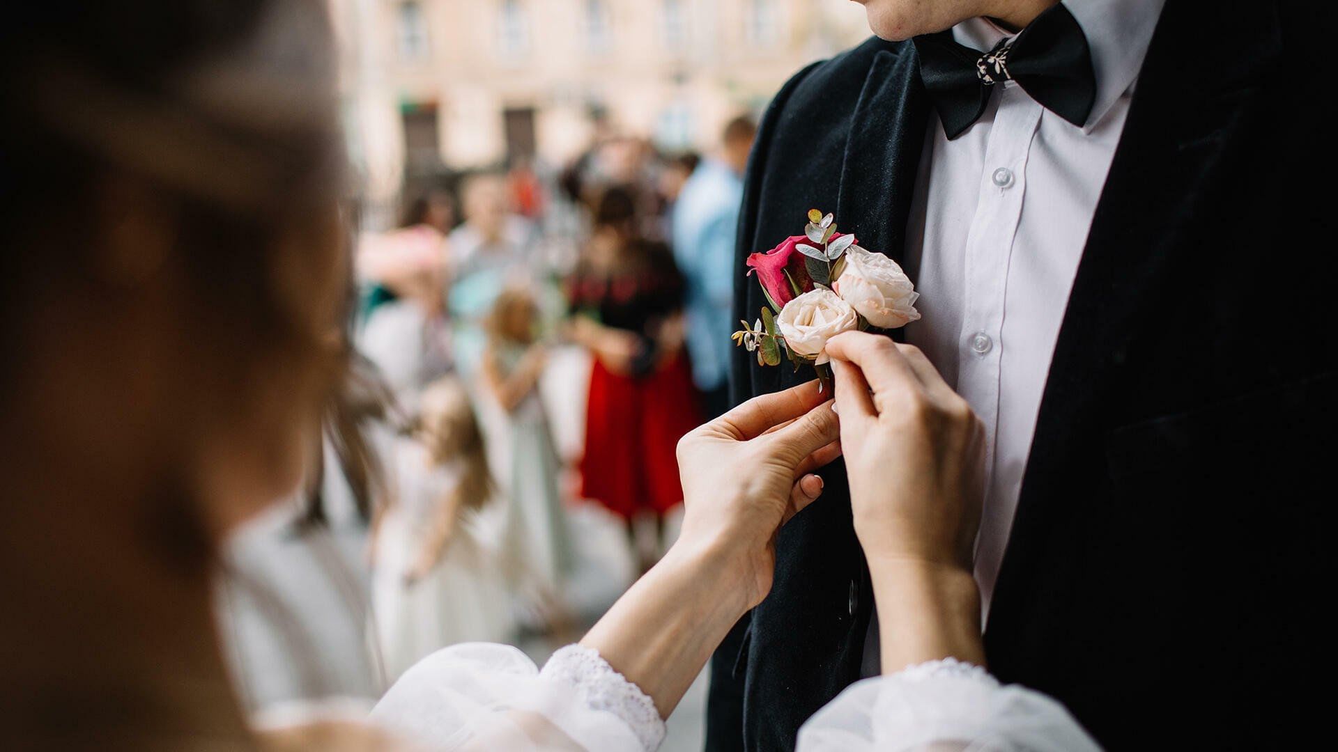 Close-up of the Bride pinning flowers on the Grooms coat at The Explorean Kohunlich